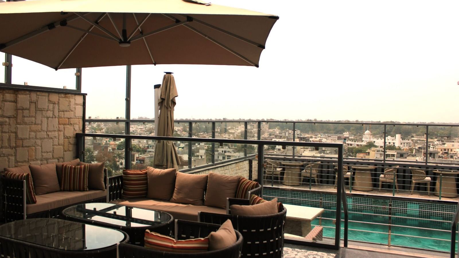 A rooftop lounge with a spacious patio and an adjacent swimming pool at BluSalzz Residence, Amritsar